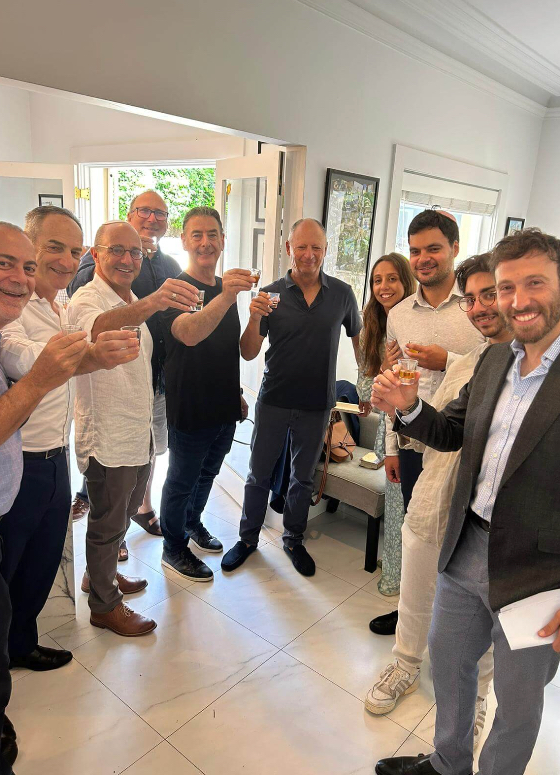 A group of people raising glasses together in celebration inside a home