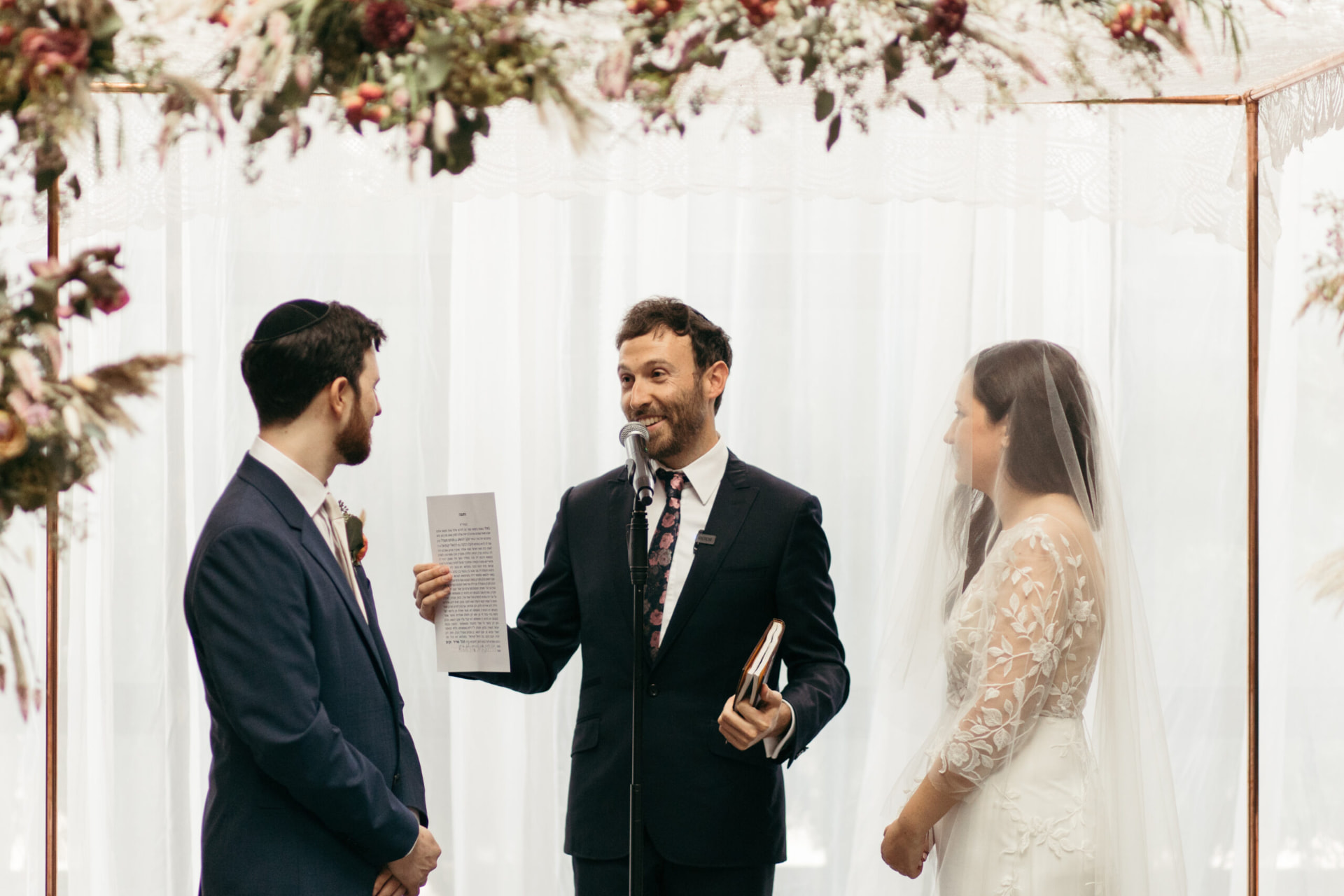 Rabbi Yossi Friedman reading the ketubah at a wedding ceremony